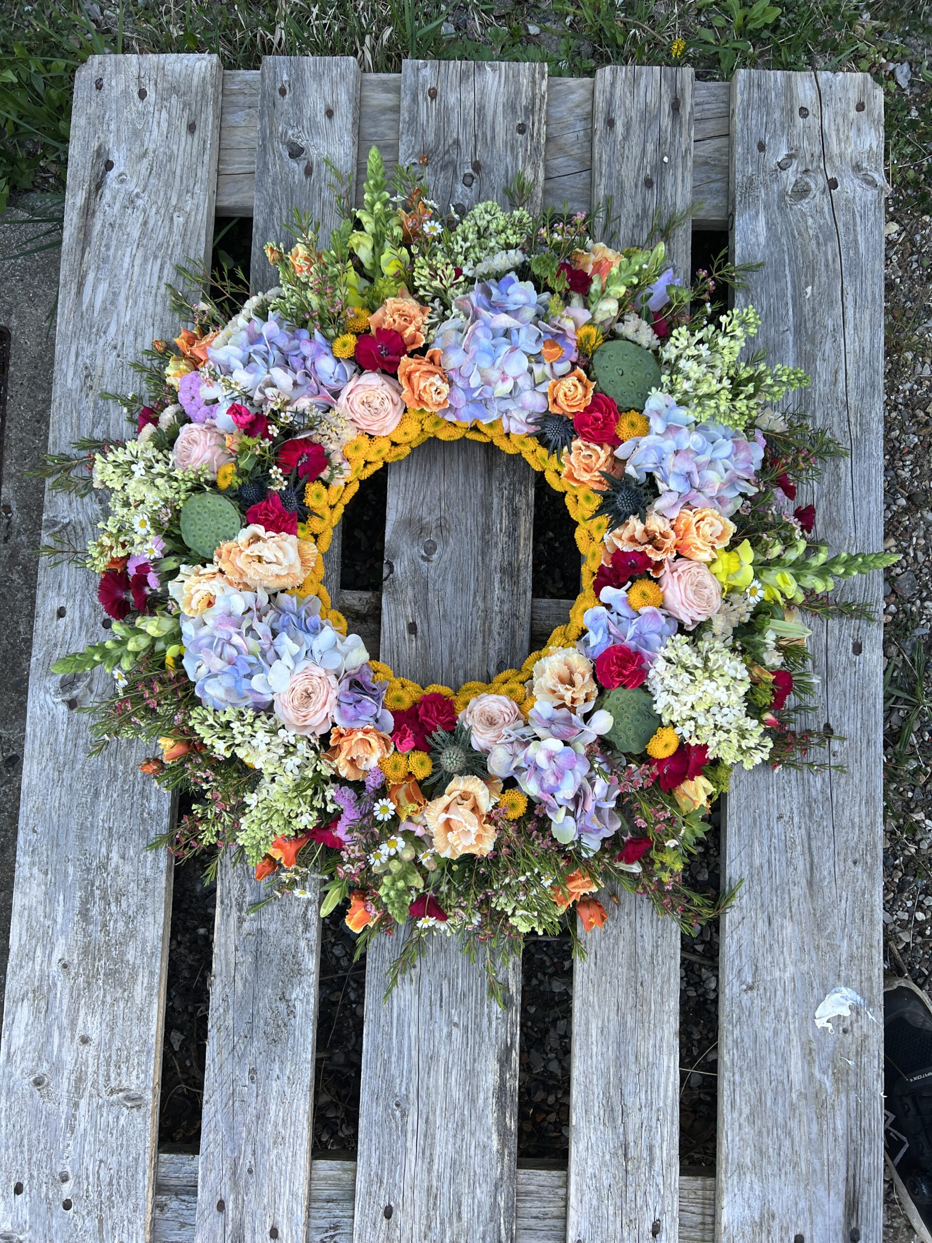Pyntet blomsterkrans i lyse og varme farver
